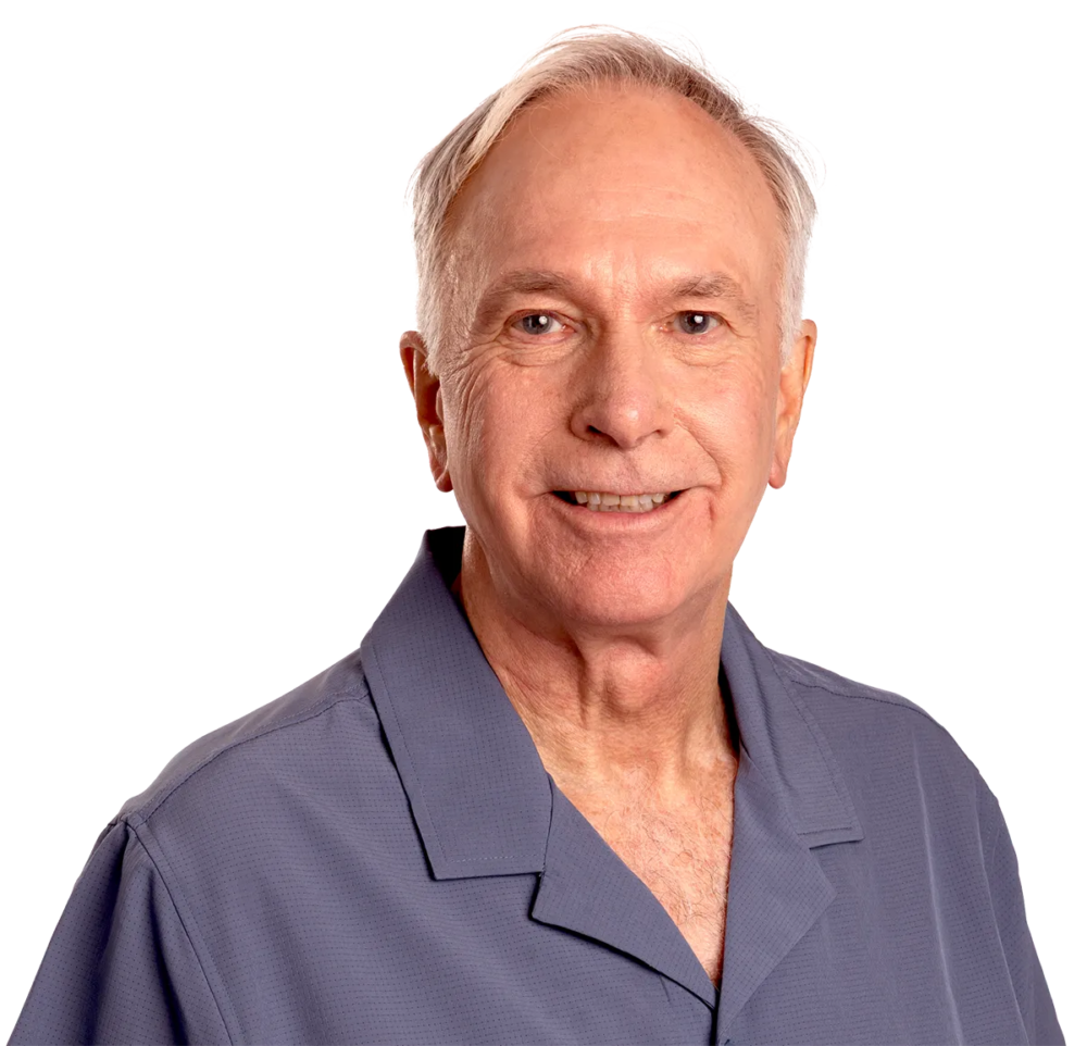 A smiling older man with white hair, wearing a grey shirt. Real patient.